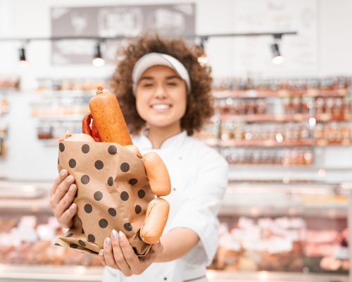 female-butcher-holding-bag-with-sausages.jpg